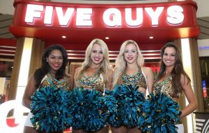 cheerleaders in front of a restaurant Five Guys