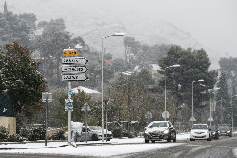 Cars driving on a snow-covered road in Marseille, December 2, 2017 