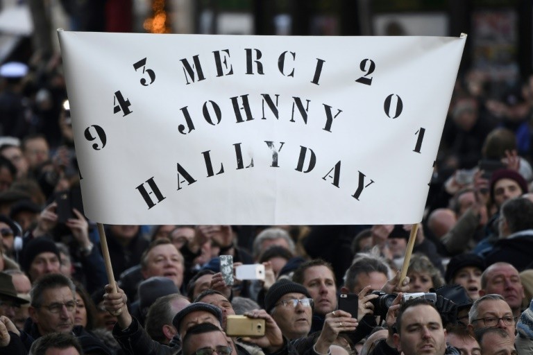 The crowd waved a placard "Thanks Johnny Hallyday," December 9, 2017 at the Church of the Madeleine in Paris