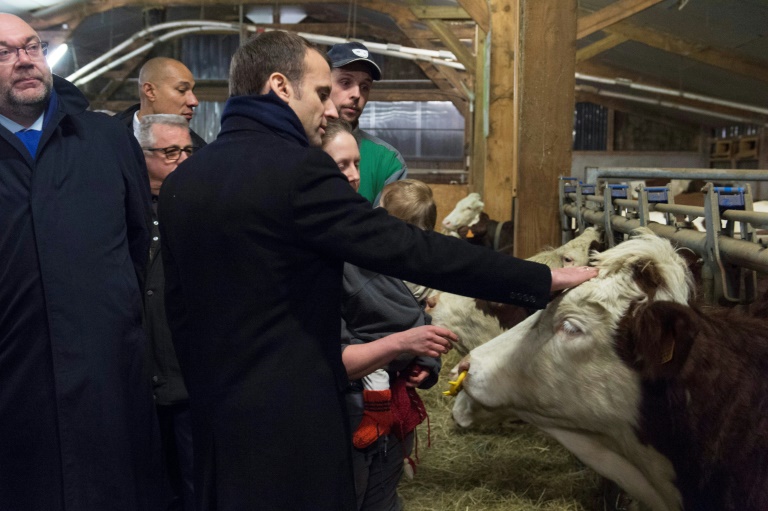 French President Emmanuel Macron (C) and Minister of Agriculture Stephane Travert (G) visit a farm in Aurieres on January 25, 2018.