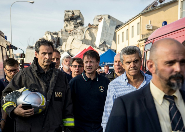 Italian Prime Minister Giuseppe Conte (C) on the site of the collapse of the motorway bridge in Genoa on 14 August 2018.