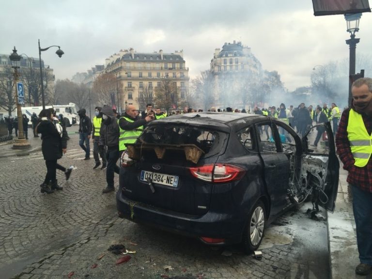 Yellow Vest protesters set fire to a car on the Champs Elysees. 