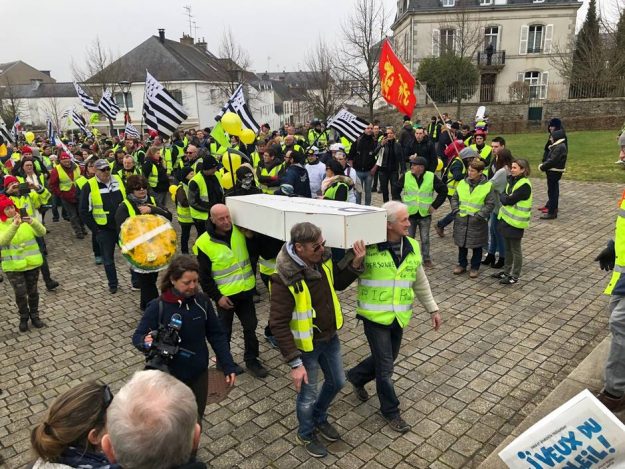 Protesters lay a coffin symbolizing democracy at the foot of the monument to the dead in Pontivy.