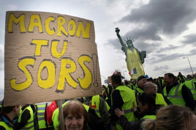 "Yellow vests" in Colmar, March 2, 2019, claim the departure of Emmanuel Macron, near a replica of the Statue of Liberty wearing a yellow vest.