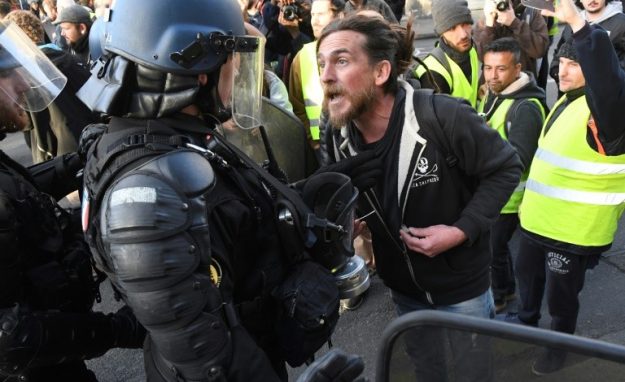 A protester facing a mobile policeman during a demonstration of "yellow vests", March 2, 2019 in Bordeaux.