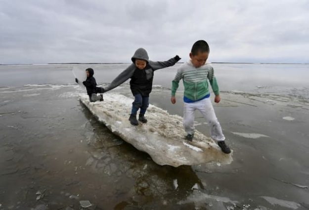 Children play on a piece of ice near the Eskimo village of Yupik, Alaska (USA), April 19, 2019. 