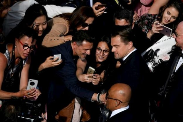 American actor Leonardo DiCaprio (D) poses on May 21, 2019 in Cannes for fans. 