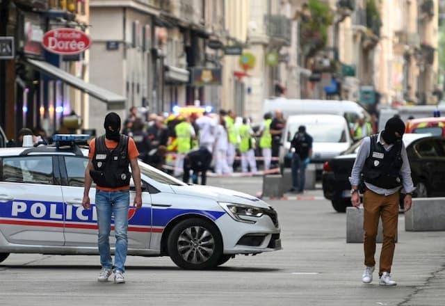 Police officers secure a perimeter in front of "La Brioche dorée" after the explosion of a parcel bomb on a pedestrian street in Lyon on May 24, 2019.