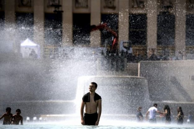 Young people cool off in a fountain on the Trocadero esplanade in Paris, on June 24, 2019.