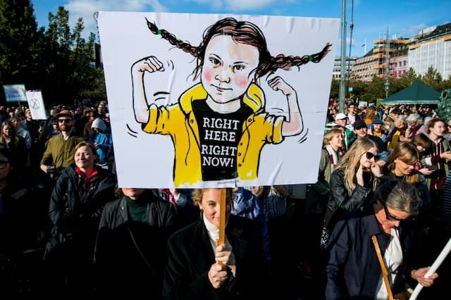 A protestor holds up a sign depicting Greta Thunberg in Montreal on September 27, 2019.