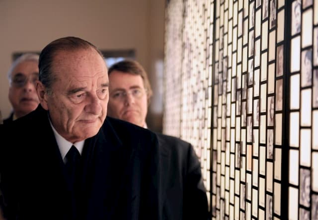 President Jacques Chirac, who died on September 26, 2019, is looking at photos of victims of the Holocaust on January 27, 2011, during the inauguration of a memorial dedicated to Jewish children rounded up and brought to the Vel D'Hiv in July 1942.