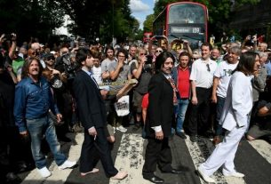 Look-alikes cross the pedestrian crossing of Abbey Road, made famous by the Beatles 50 years earlier, on August 8, 2019 in London.