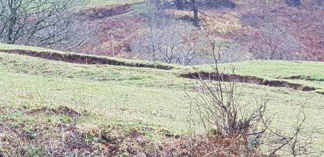 The damage is also visible in the fields nearby, with significant crevices 