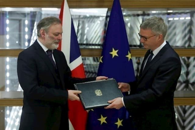 UK representative Tim Barrow hands over official document showing London has fulfilled legal obligations to leave the EU to Secretary General of the European Council Jeppe Tranholm-Mikkelsen on January 29, 2020 in Brussels.