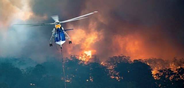 A helicopter combats the flames which ravage the south-east of Australia, in the State of Victoria, on December 31, 2019.