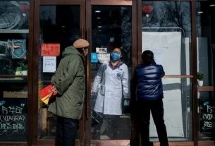 People wait outside a Beijing pharmacy on February 15, 2020.