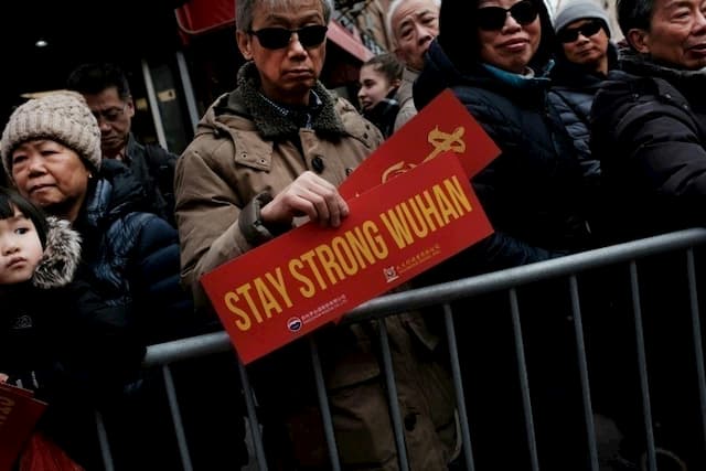 A man displays a "Stay Strong Wuhan" message in solidarity with the hometown of the new coronavirus epidemic in China during a ceremony celebrating the Lunar New Year on February 9, 2020 in New York.