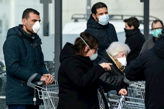 People wearing protective masks go shopping in a supermarket on February 23, 2020 in Casalpusterlengo, Italy.