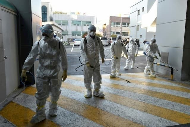 Health workers disinfect the surroundings of a church where cases of coronavirus were detected on February 19, 2020 in Namgu, South Korea.