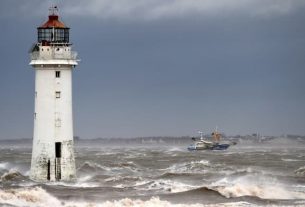 A fishing boat passes on February 9, 2020 in front of the lighthouse in New Brighton, in the north-west of England, where the storm Ciara arrived.