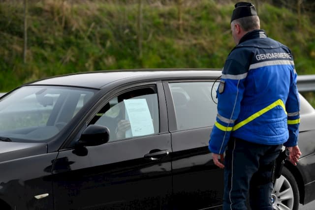 A gendarme controls a motorist, in Pleurtuit (Ille-et-Vilaine), on March 20, 2020.
