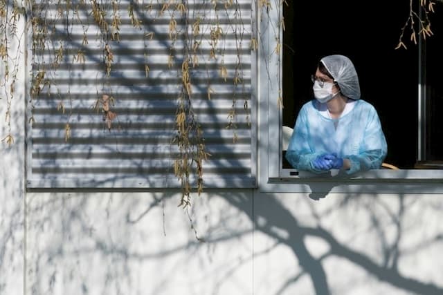 A member of the nursing staff rests for a few minutes at the window of the Emile Muller hospital in Mulhouse, on March 24, 2020