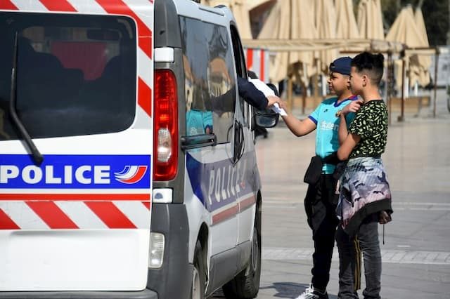 Police check the certificates of two teenagers on Place de la Comédie on March 18, 2020 in Montpellier, during the confinement instituted in France to fight against the new coronavirus. 