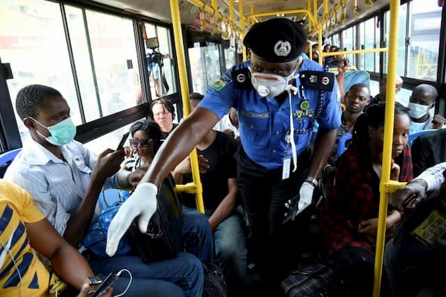 Control in a bus in Lagos where a police officer explains the barrier gestures to passengers, March 26, 2020.