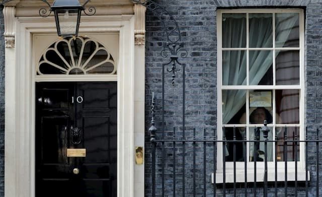 An employee of 10 Downing Street sticks on the window of the Prime Minister's residence the drawing of a rainbow, symbol of hope, on April 9, 2020