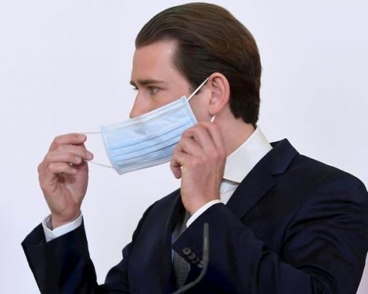Austrian Chancellor Sebastian Kurz takes off his protective mask during a press conference on April 6, 2020 in Vienna on the coronavirus epidemic.