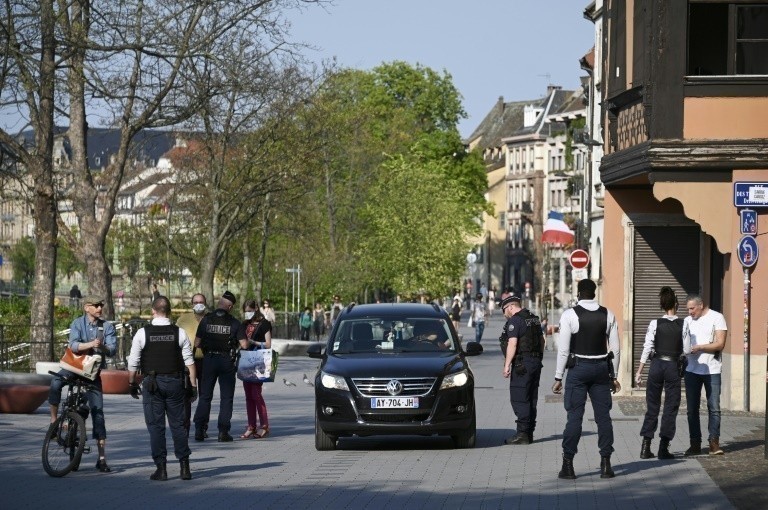 Police check pedestrians and a motorist on a street in Strasbourg, April 9, 2020 during the confinement established in France to fight against the coronavirus.