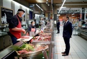 Emmanuel Macron chats with an employee in a Super U in Saint-Pol-de-Léon, April 22, 2020.