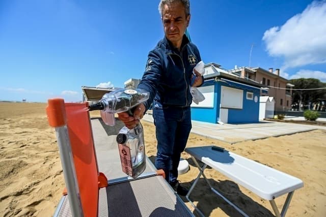 An employee disinfects deckchairs on a private beach in Jesolo, east of Venice, on May 12, 2020 in Italy.