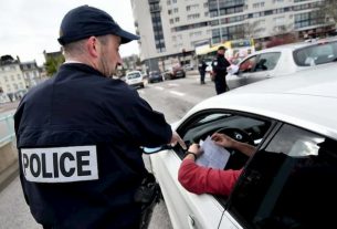 A police officer checks a travel certificate during the first confinement.